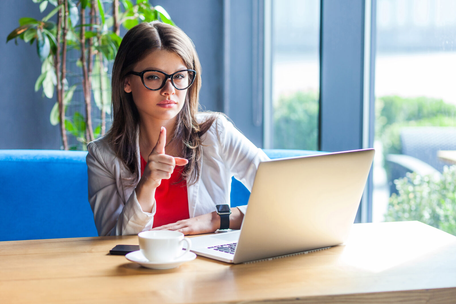 パソコンを見ながら指を立てる女性。疲れや不調の小さなサインに気づくイメージ